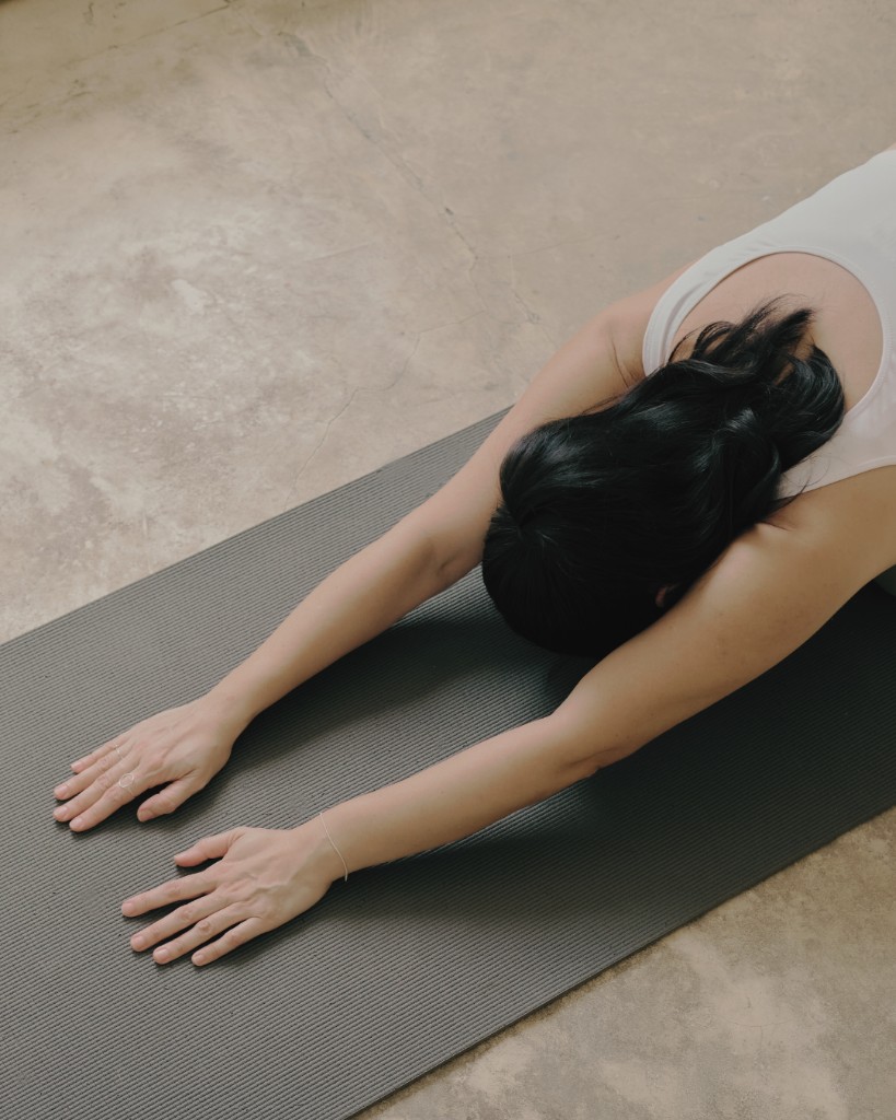 Woman in Child's Pose on a yoga mat, viewed from above