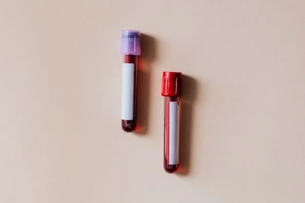 Two blood collection tubes with lavender and red caps on a neutral surface